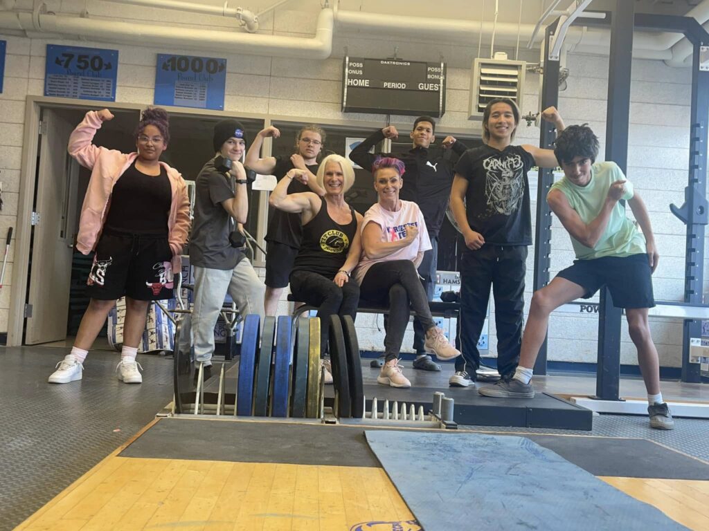 FITCLUB Foundation founder, tutor and students flexing their arms