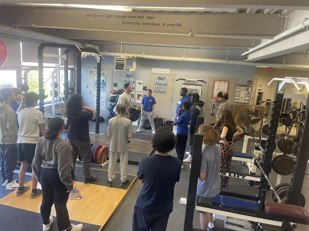 Students watching tutor demonstrate how to do a workout 